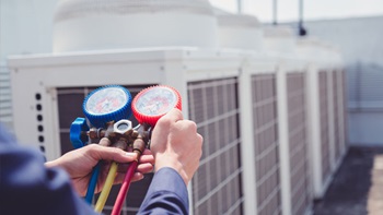 técnico a carregar o gás de um aparelho de ar condicionado